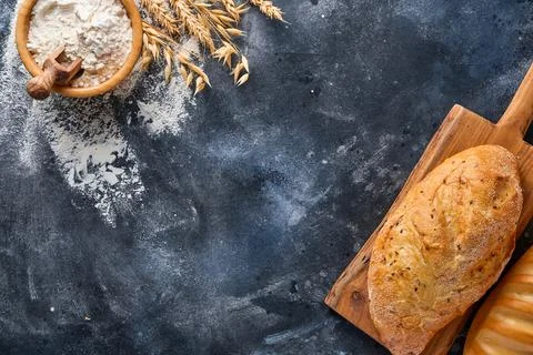 Various crispy breads and buns, wheat flour and ears on gray old concrete bac Stock Photos