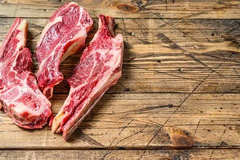 Various cuts of raw beef meat. Wooden background. Top view. Copy space Stock Photos