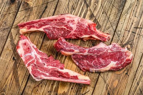 Various cuts of raw beef meat. Wooden background. Top view Stock Photos