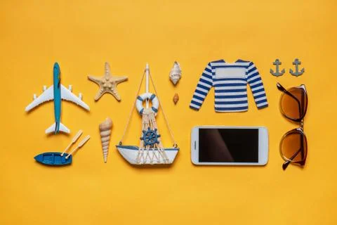 Various decorative nautical items, plane, sailboat, sunglasses and smartphone Foto stock