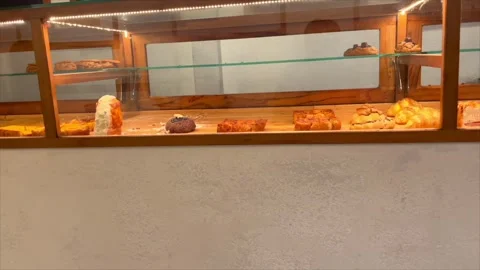 Various delicious pastries and bread displayed in a wooden bakery showcase Video stock 333638833