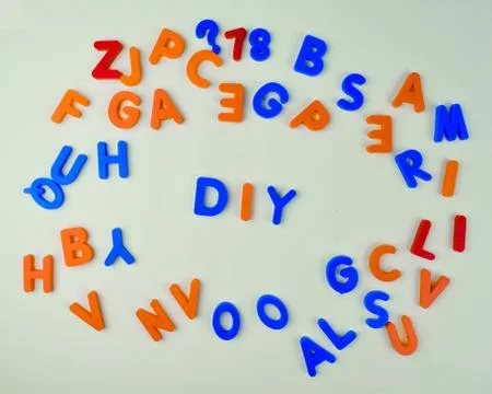 Various different colored letter blocks scattered across a white background Stock Photos