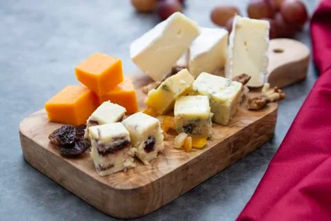 Various different types of cheese slices, cheese mix on wooden cutting board. Stock Photos