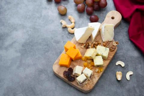 Various different types of cheese slices, cheese mix on wooden cutting board. Stock Photos