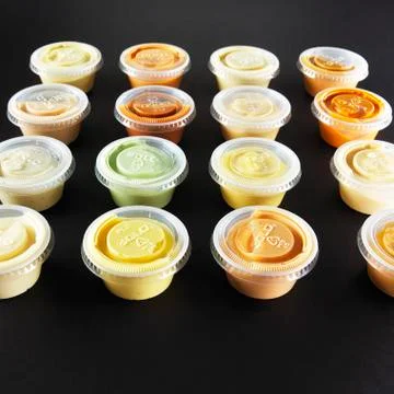 Various dips in small plastic bowls Stock Photos