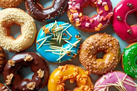 Various donuts on blue background, from above Stock Photos