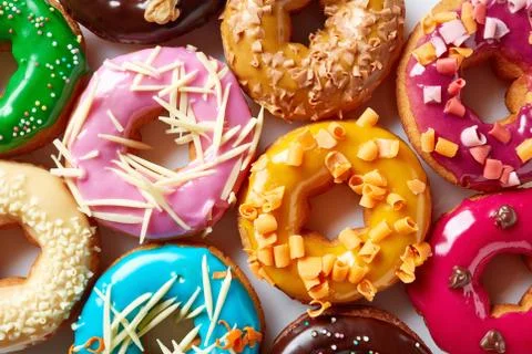 Various donuts on white background, from above Stock Photos