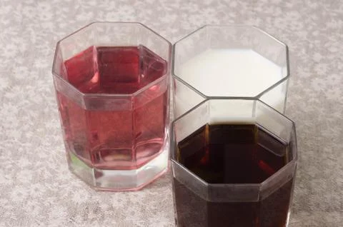 Various drinks in three glasses on the background of a linen tablecloth Stock Photos