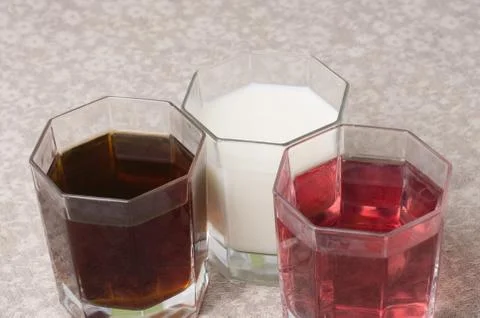Various drinks in three glasses on the background of a linen tablecloth Stock Photos