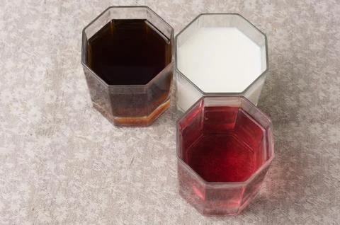 Various drinks in three glasses on the background of a linen tablecloth Stock Photos