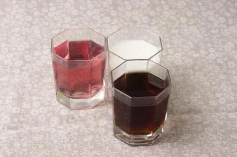 Various drinks in three glasses on the background of a linen tablecloth Stock Photos