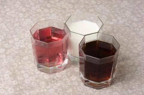 Various drinks in three glasses on the background of a linen tablecloth Stock Photos