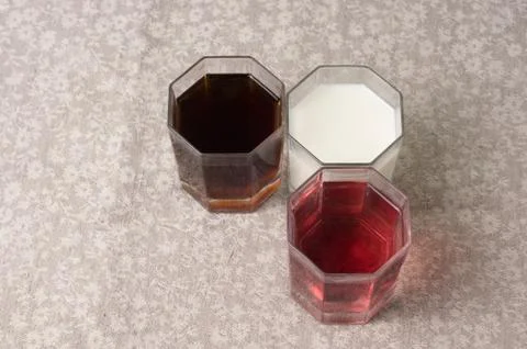 Various drinks in three glasses on the background of a linen tablecloth Stock Photos