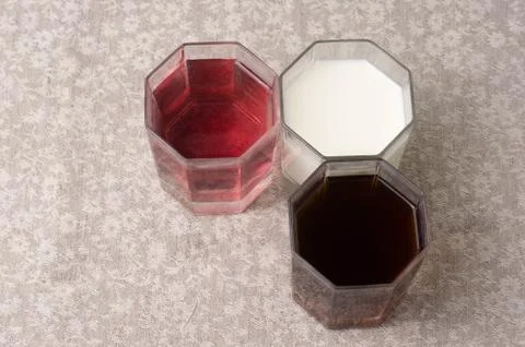 Various drinks in three glasses on the background of a linen tablecloth Stock Photos