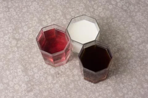 Various drinks in three glasses on the background of a linen tablecloth Stock Photos