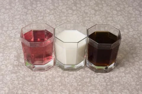 Various drinks in three glasses on the background of a linen tablecloth Stock Photos