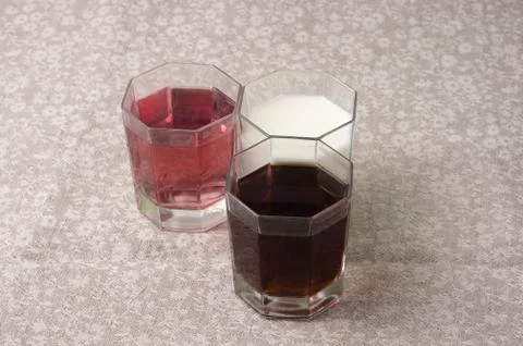 Various drinks in three glasses on the background of a linen tablecloth Stock Photos