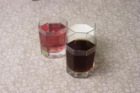 Various drinks in three glasses on the background of a linen tablecloth Stock Photos