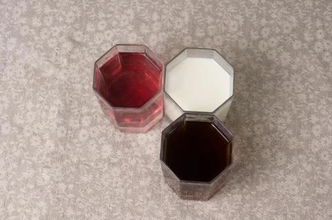 Various drinks in three glasses on the background of a linen tablecloth Stock Photos