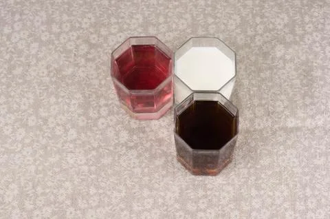 Various drinks in three glasses on the background of a linen tablecloth Stock Photos