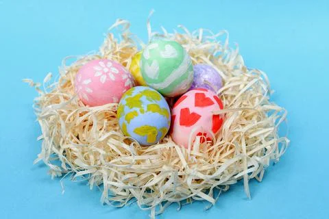 Various Easter eggs in the nest on the blue background Foto stock