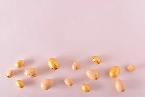 Various Easter eggs of yellow shades lie on a pink background. Easter backgro Foto stock