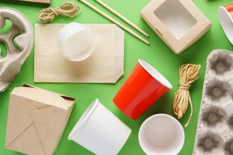 Various eco-friendly packaging, containers on green background. Stock Photos
