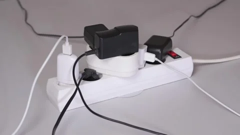 Various electrical appliances plugs connected to the white extension cord Stock-Footage 305251174