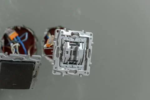 Various electrical components are showcased on a gray wall, highlighting ex.. Stock Photos