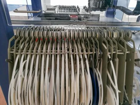 Various electronic component reels loaded in feeders of Pick and Place machin Stock Photos