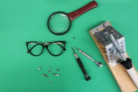 Various electronic components and tools are on a green table repair of Stock Photos