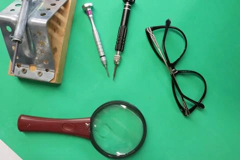 Various electronic components and tools are on a green table repair of Stock-Fotos