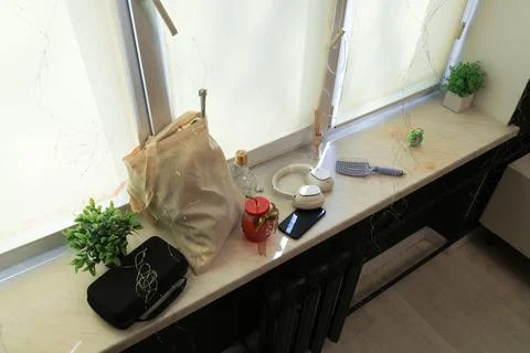 Various everyday items arranged on a windowsill with decorative fairy lights Stock Photos