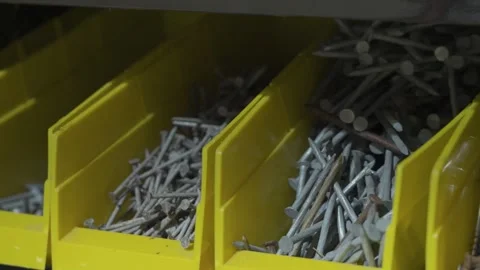 Various fasteners sorted into bins on a workbench. 库存影片 340923395