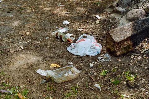 Various garbage, plastic bags, containers, bottles and food waste are scattered Stock Photos