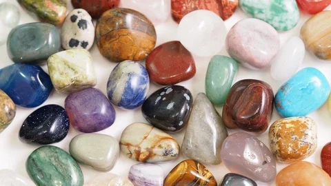 Various gemstones rotating on white table close up Stock Footage 102452553