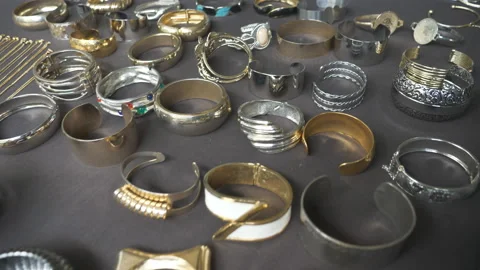 Various gold, silver and iron bracelets on a display shelf. Stock Footage 111142115