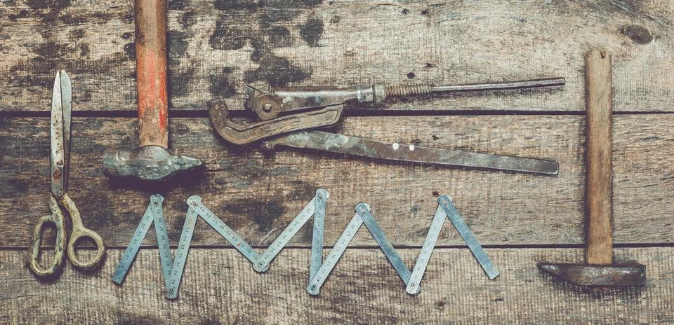 Various hand tools arranged on a rustic wooden surface for repair and Stock Photos