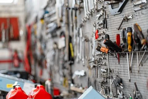 Various hand tools organized on pegboard in workshop Foto stock