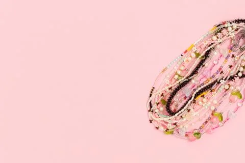 Various handcrafted beads on a pink background. Stock Photos