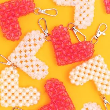 Various handmade keychains in a heart shape made from acrylic beads. Stock Photos