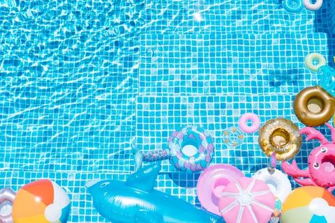 Various inflatable on a pool water background. ball, crab, dolphin, float. su Stock Photos