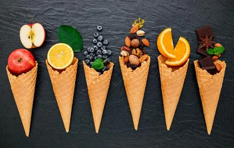 Various of ingredient for ice cream flavor in cones set up on dark stone back Stock Photos