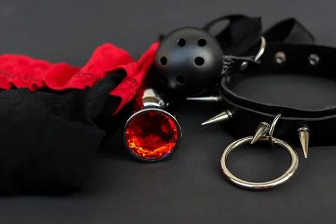 Various items on a dark surface including a red gem, black and red fabric, and Stock Photos