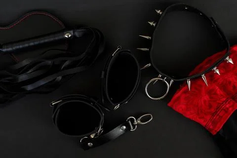 Various items used for bondage and restraint displayed on a dark surface with a Stock Photos