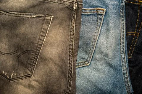 Various jeans back view. Old jeans of different colors lying on top Foto stock