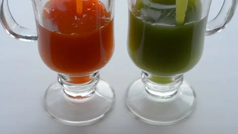 Various juices are poured into two glasses. Electoral focus Video stock 145701865