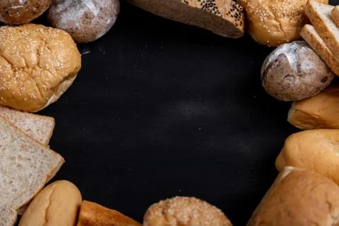 Various kinds of bread placed on the black wooden background Foto stock