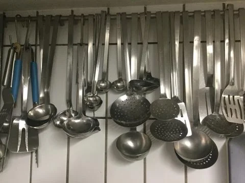 Various ladles hanging on rack in kitchen Stockfoto's