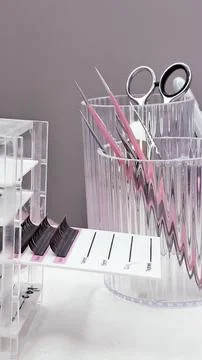 Various lash extensions, palettes, and beauty tools in soft white and pink to Stock Photos